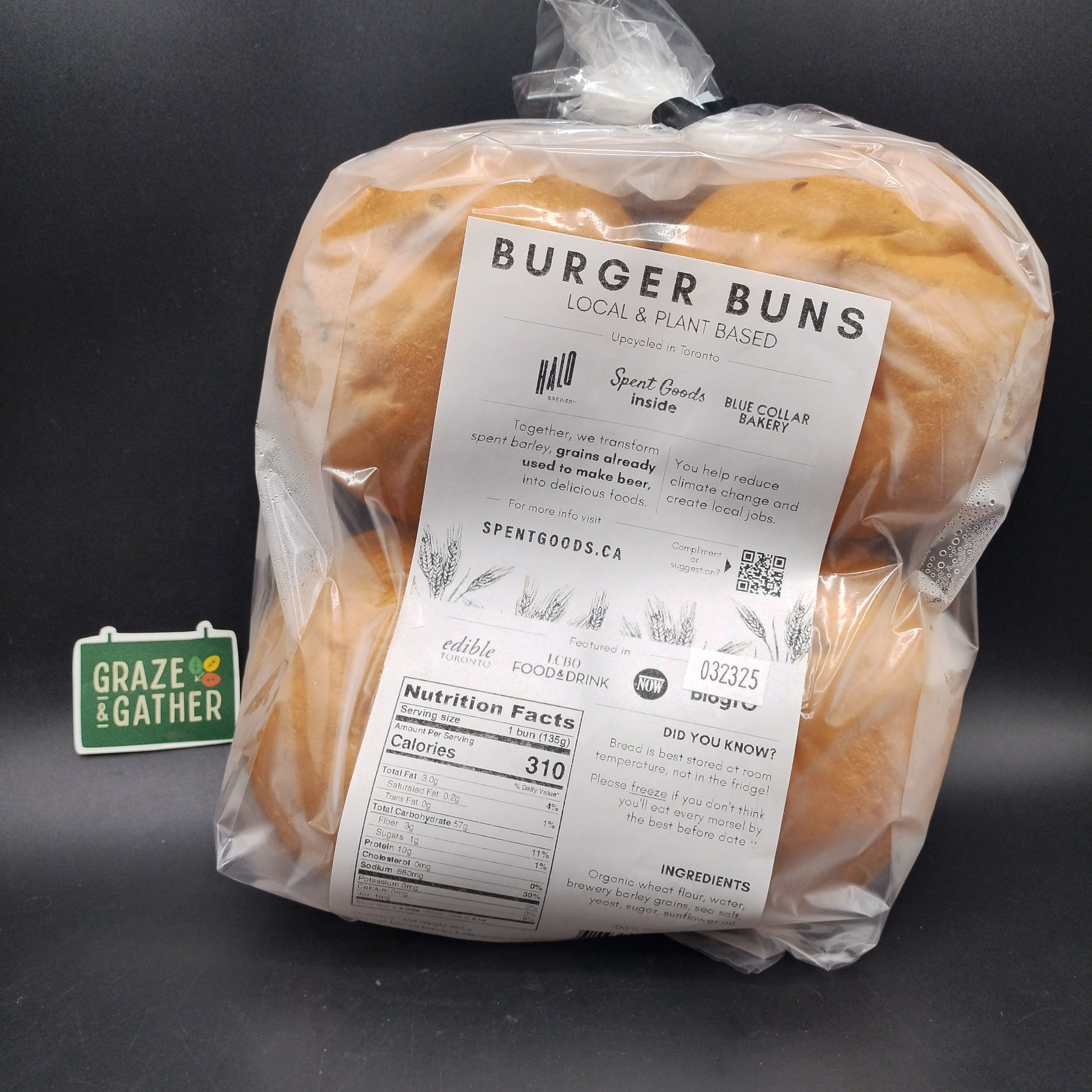 Packaged burger buns with a label on a dark surface, featuring the brand 'Grate & Feather'.