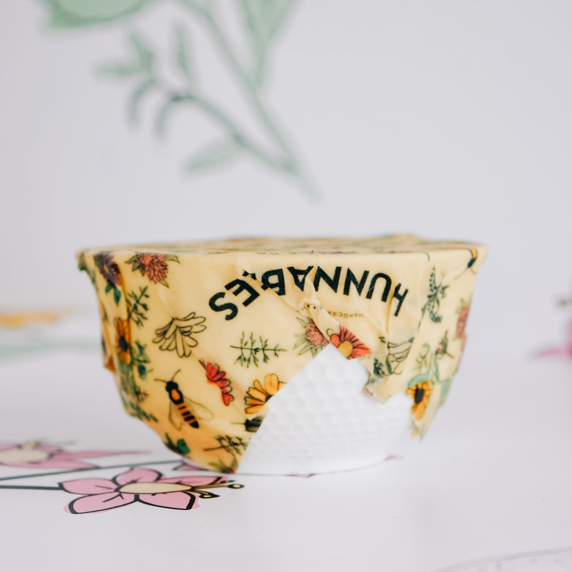 Bowl with a beeswax food wrap cover, with Hunnabees logo.