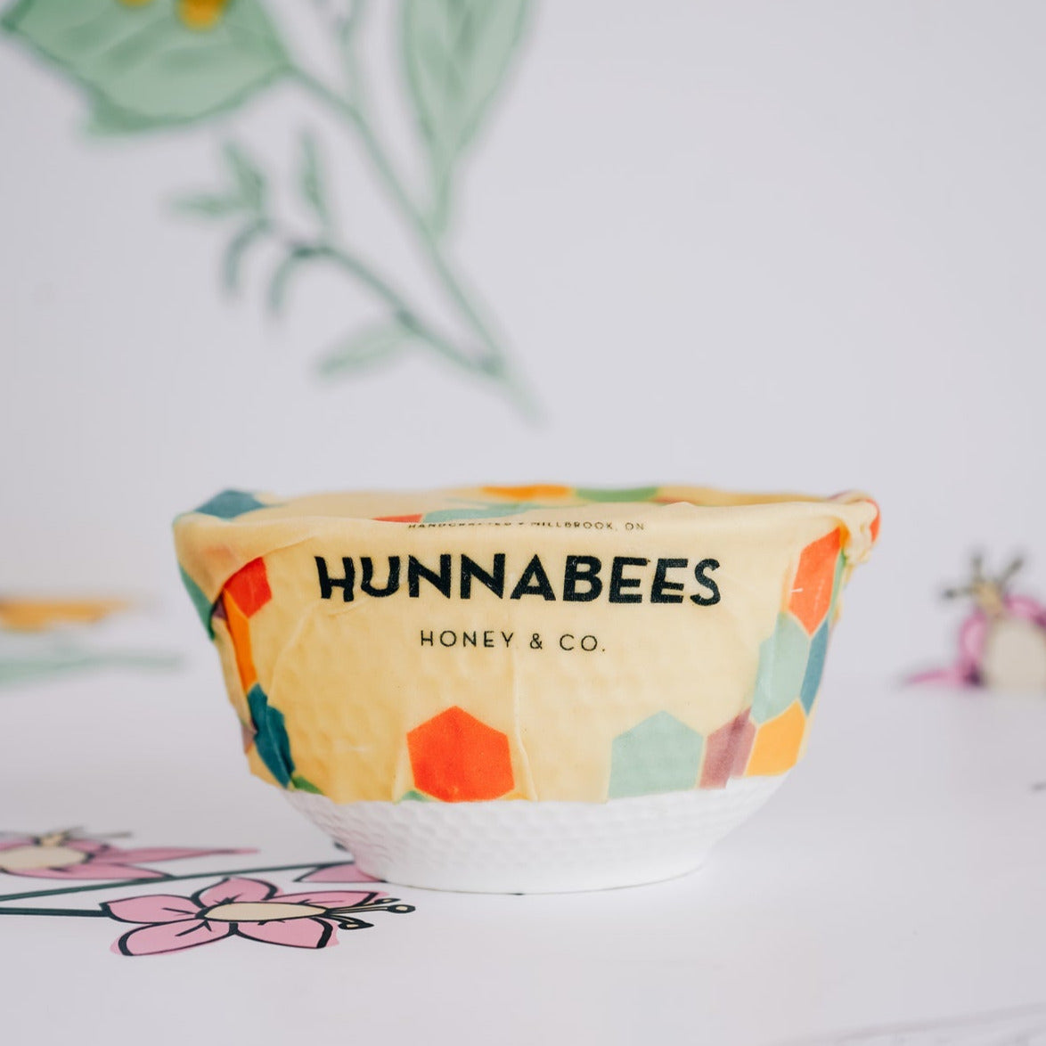 Bowl with a beeswax food wrap cover, with Hunnabees logo.