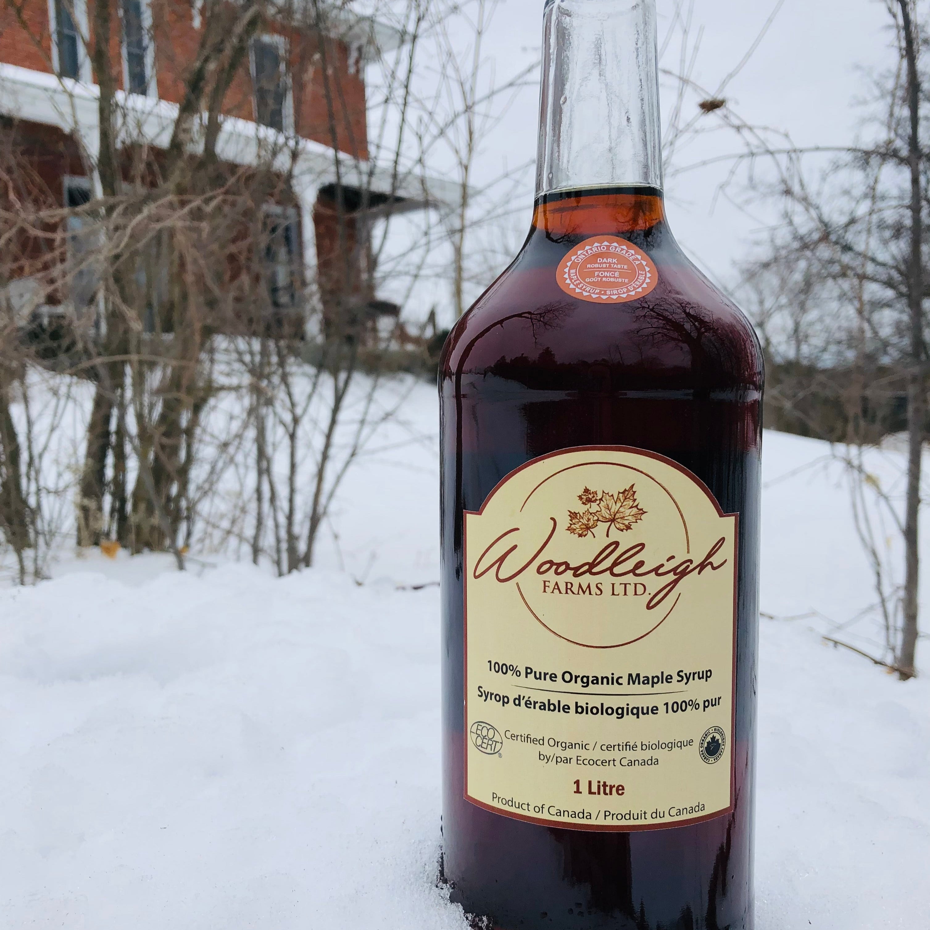 1L bottle of dark maple syrup in the snow