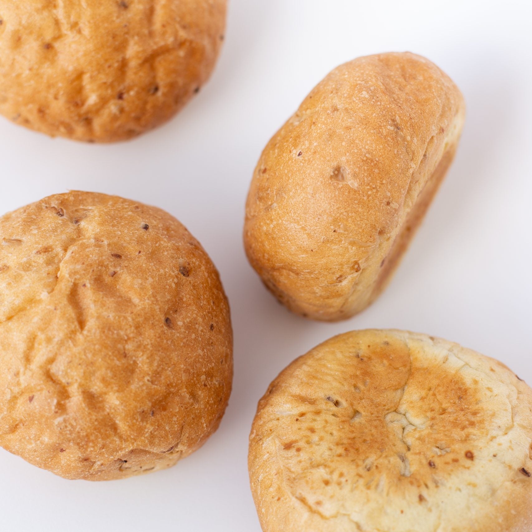 Four bread rolls on a white background