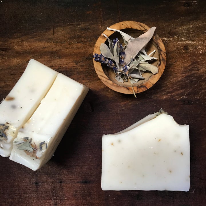 bars of lavender and white sage soap with a wooden bowl of dried sage and lavender